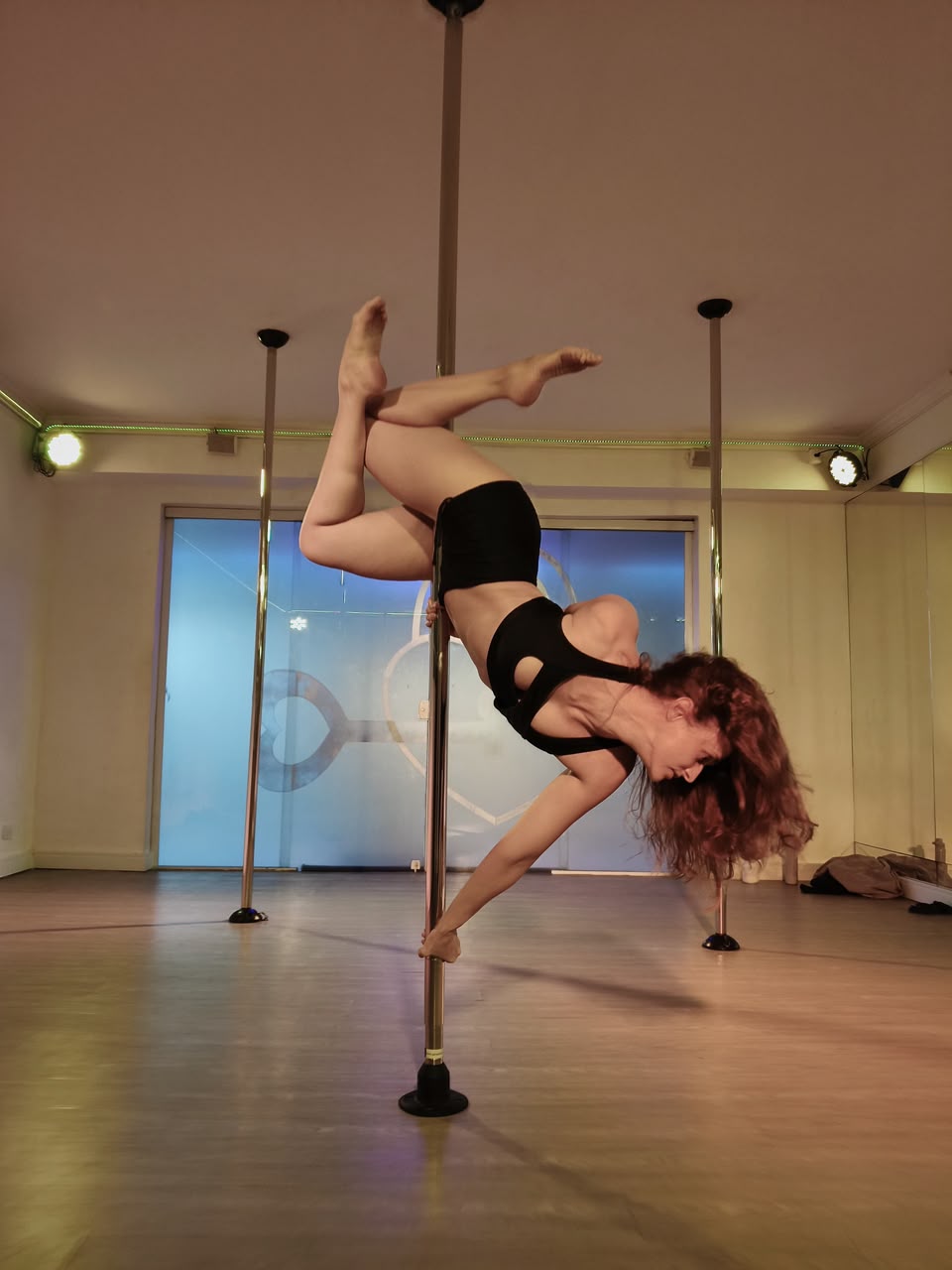 Aluna do Room 52 executando movimento de pole dance 3